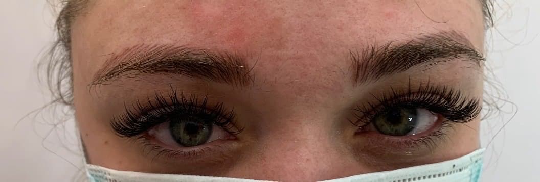 Eyelash extensions framing green eyes
