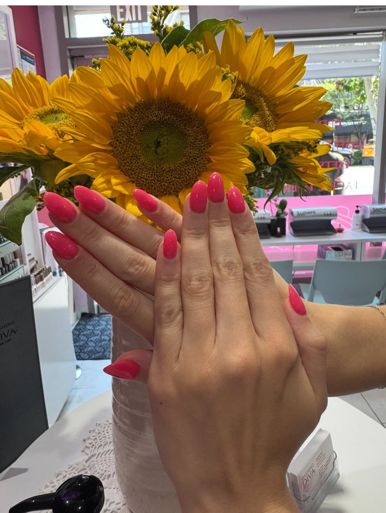 Bright pink almond nails with sunflowers
